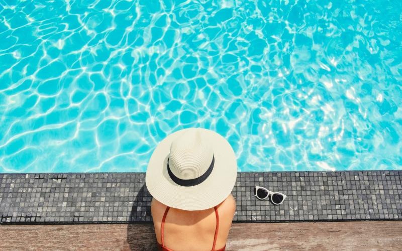 a person wearing a hat by a pool